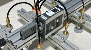 Custom vacuum gripper assembly on aluminum framing, with air lines and a vacuum controller
