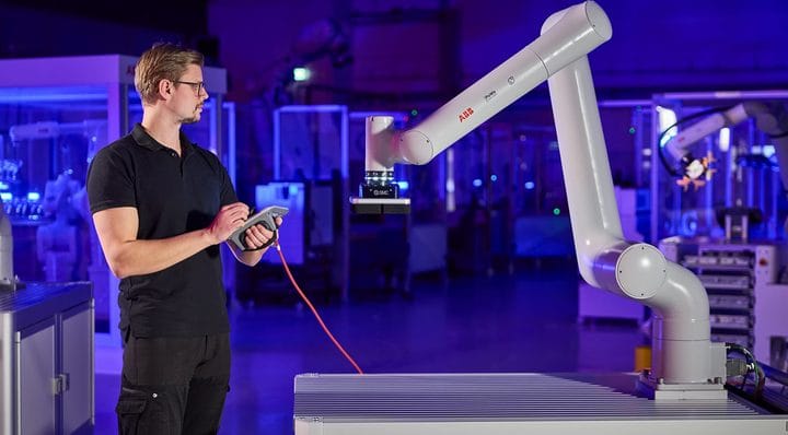 Technician with a teach pendant programming an ABB collaborative robot fitted with an SMC vacuum gripper